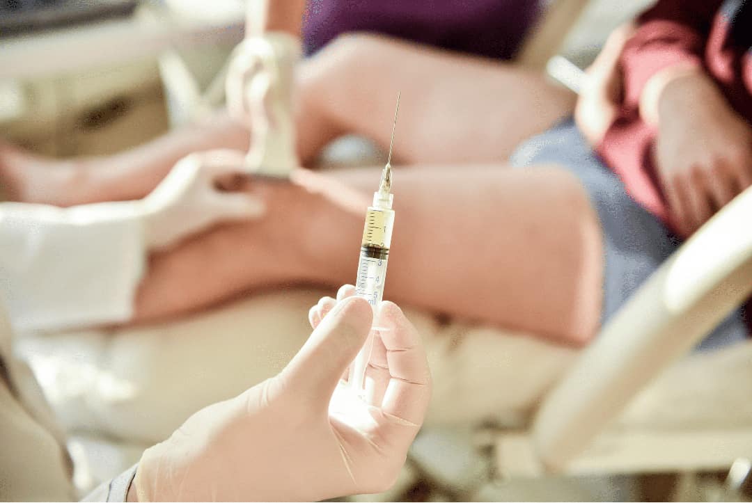 Physician performing an injection at the knee