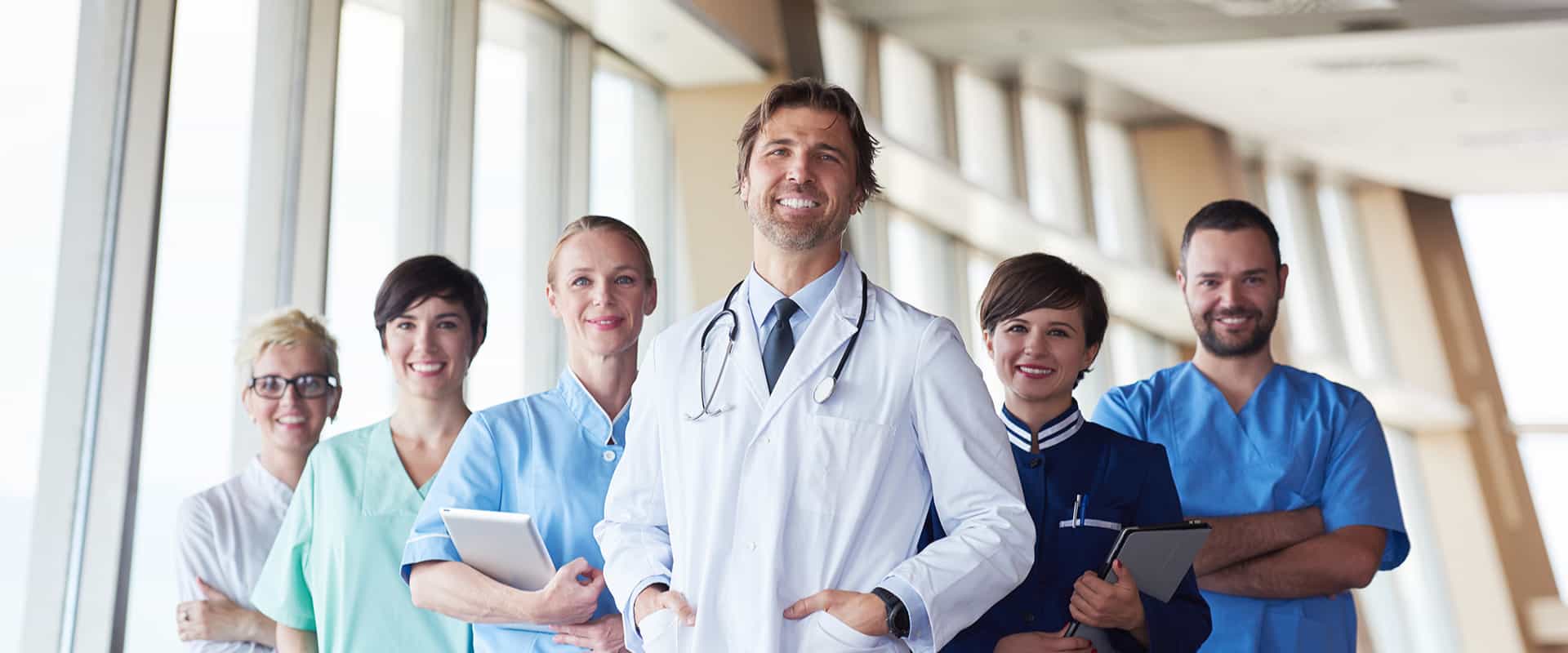 Six medical professionals are standing in a group