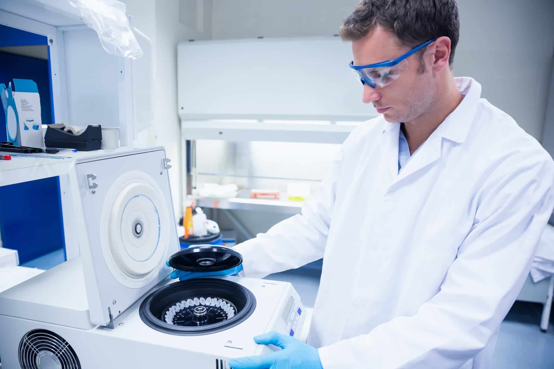 Medical researcher wearing safety glasses and using a centrifuge